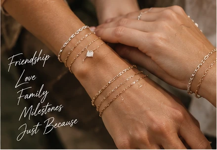 Hands adorned with delicate layered permanent jewelry
