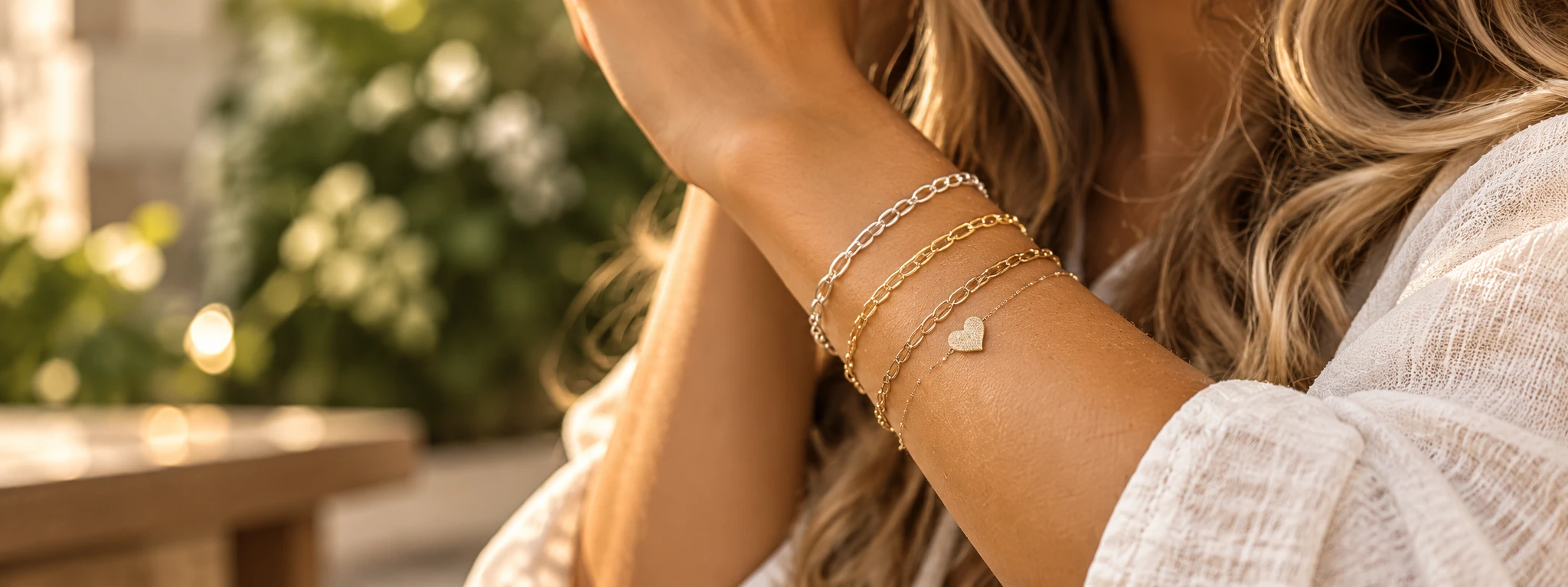 Close-up of a wrist with layered delicate gold and silver bracelets